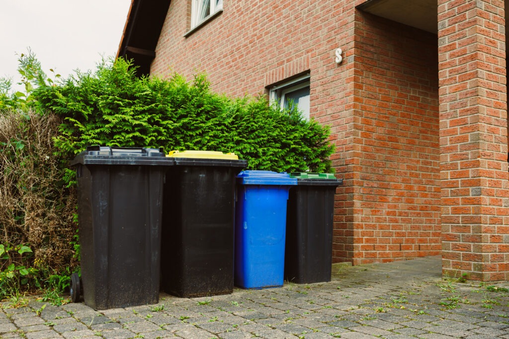 Gebäudeservice: Ordnungsgemäß aufgestellte Mülltonnen im Außenbereich einer Immobilie.