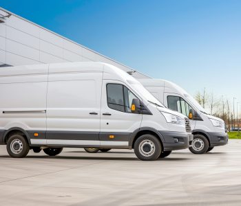Weiße Transporter für Gebäudeservice, Kleintransporte und Umzüge vor einer Lagerhalle.